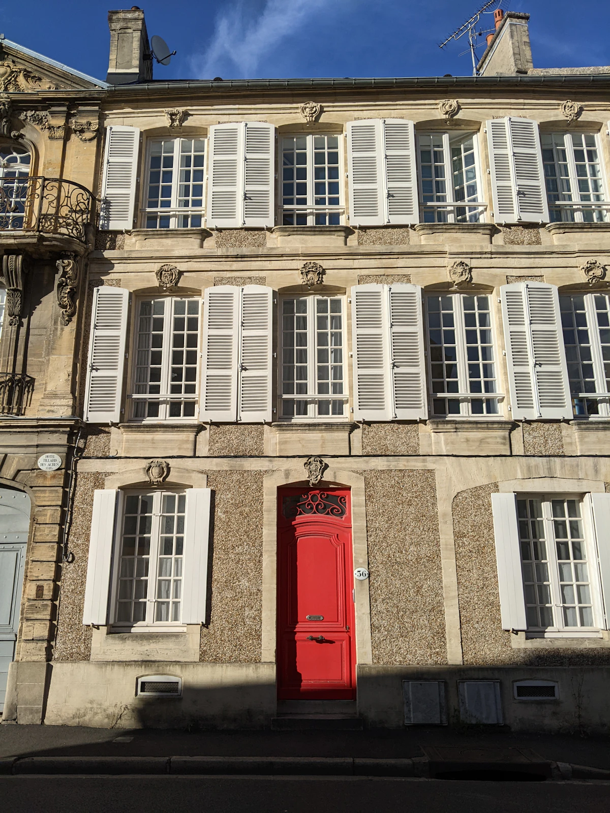Maison française traditionnelle avec porte rouge et volets blancs