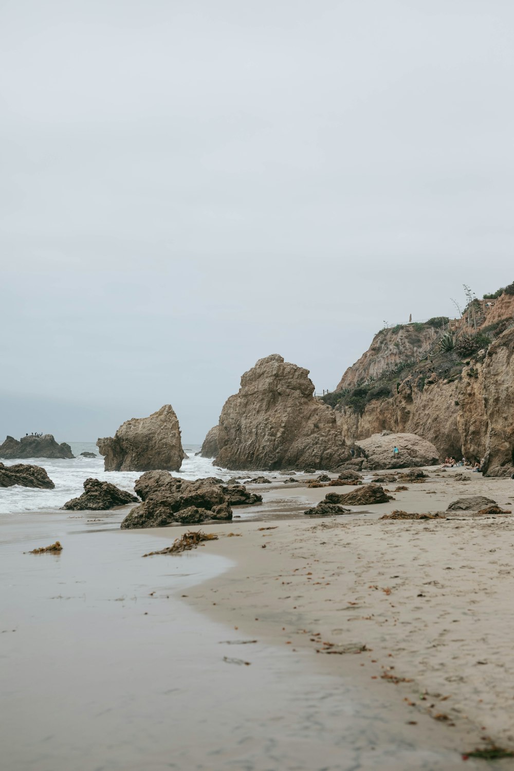 a rocky beach with a body of water in the background