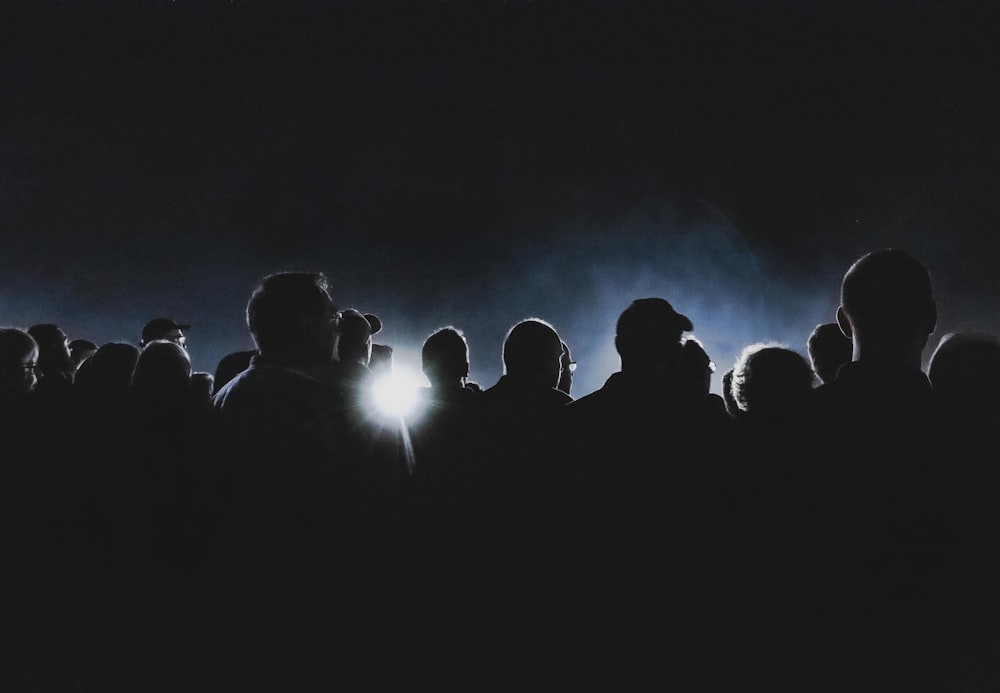 a group of people standing in a dark room with a bright light