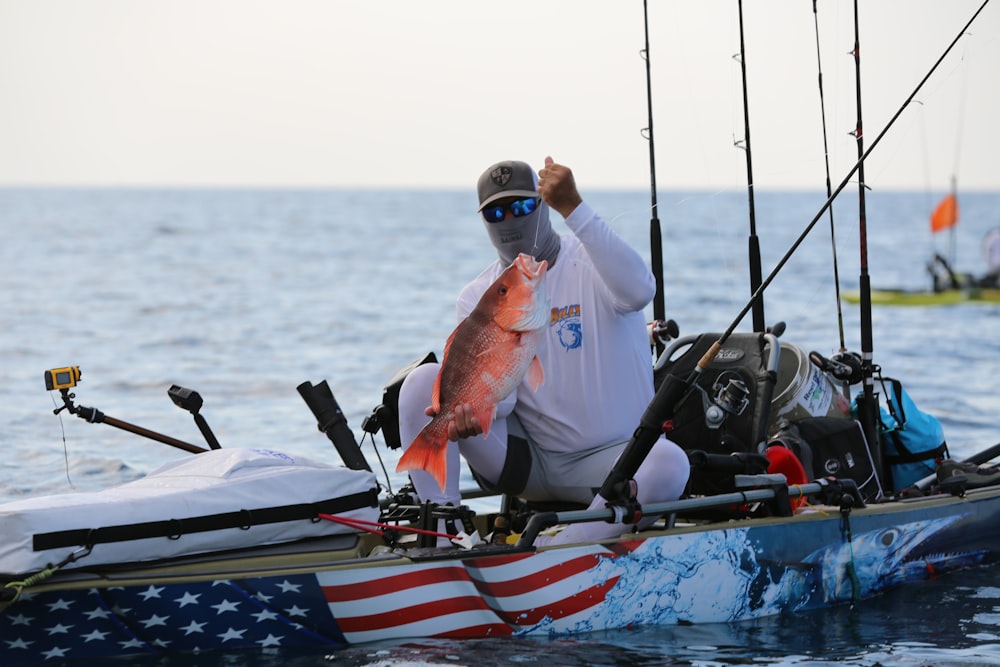 a man holding a fish on a boat