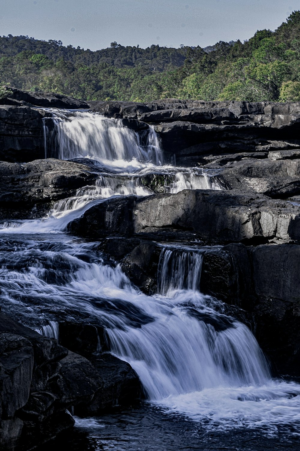 a waterfall with trees in the background