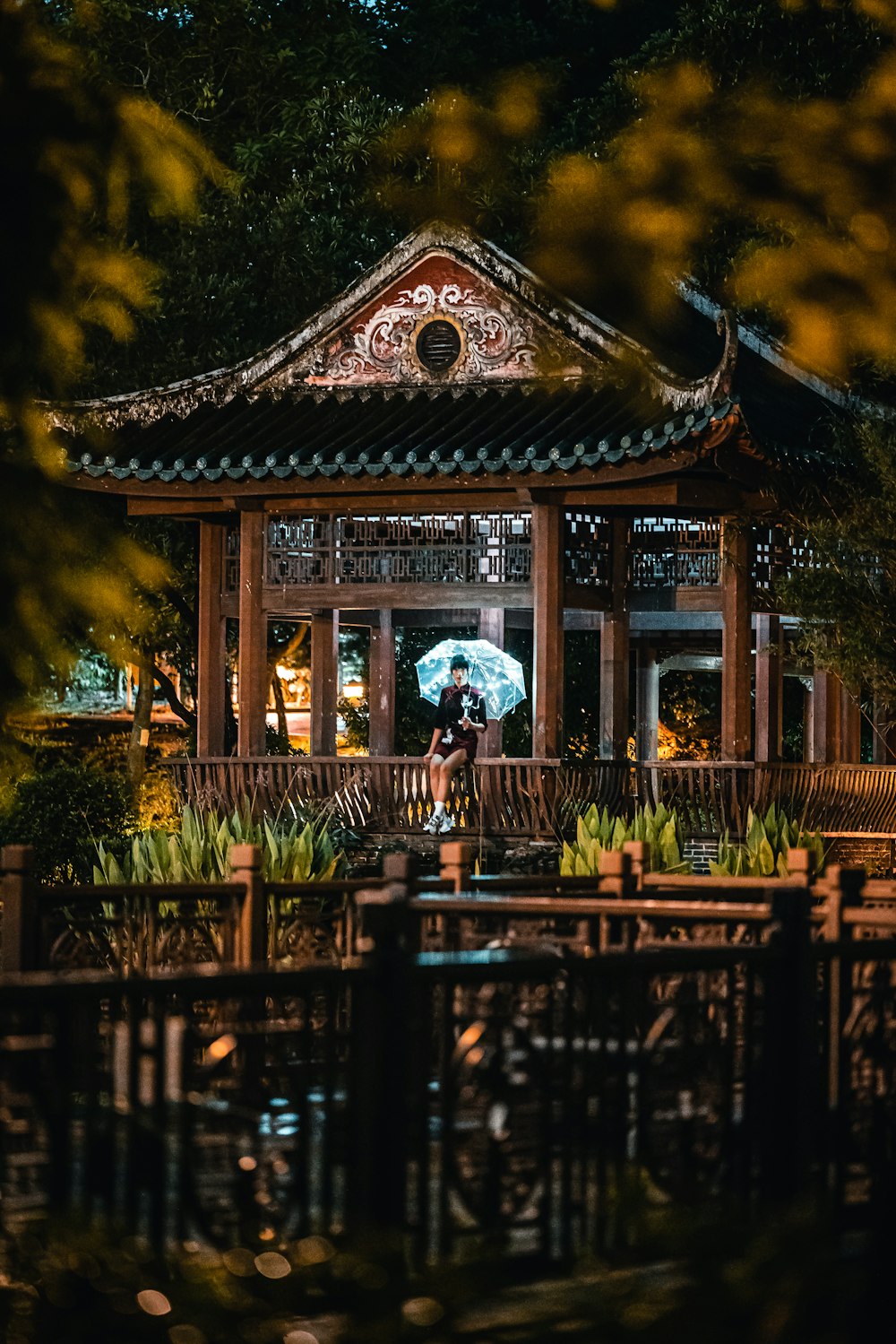 a person holding an umbrella in front of a pagoda