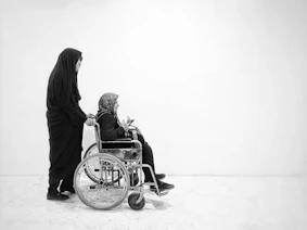 a person in a black robe pushing a baby in a wheelchair