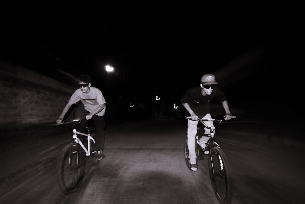 two men riding bikes at night