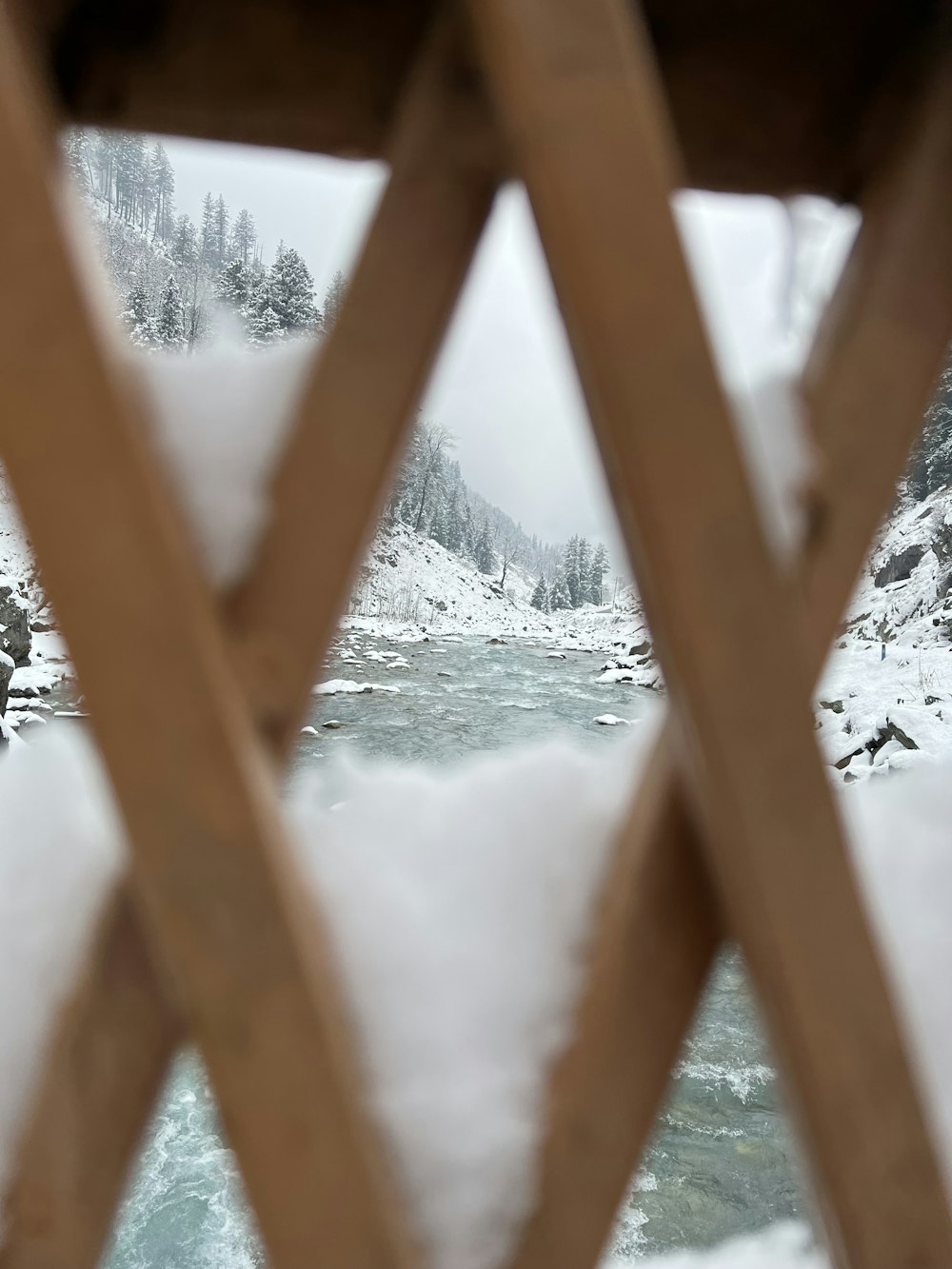 a view through a window of a snowy forest