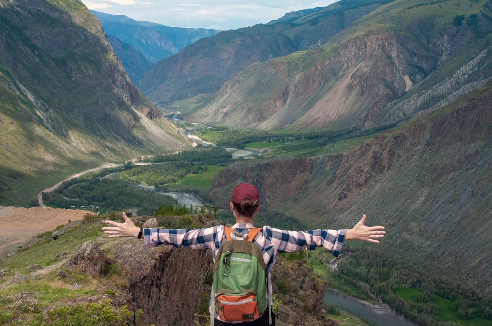 a man with his arms out on a mountain top