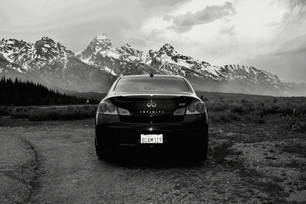 a car parked on a road with mountains in the background