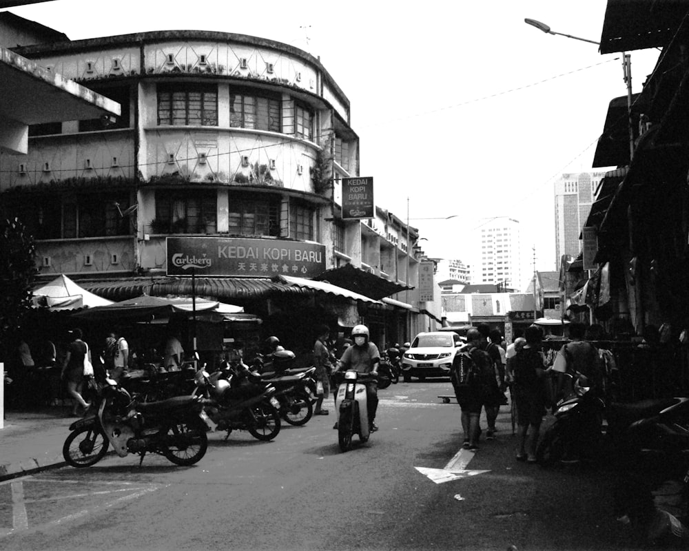 a busy street with people and motorcycles