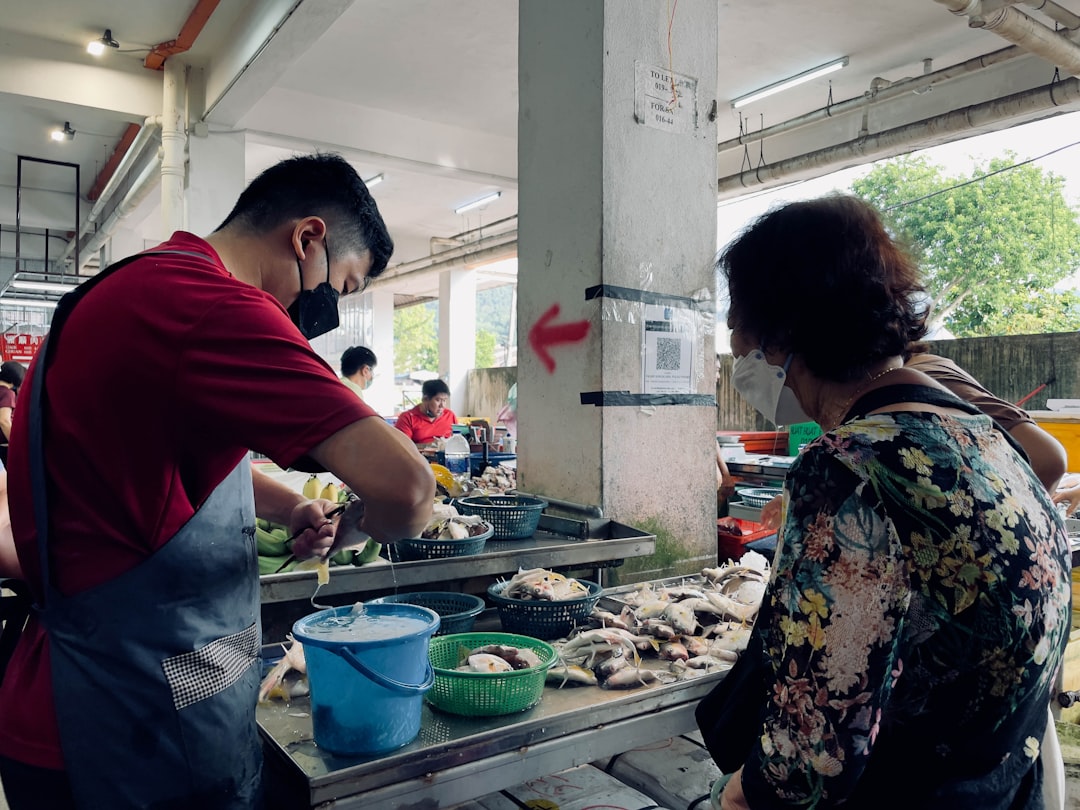 a man and woman standing next to a table with food on it,