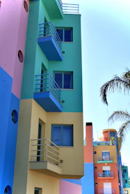 a building with balconies and a tree in the front