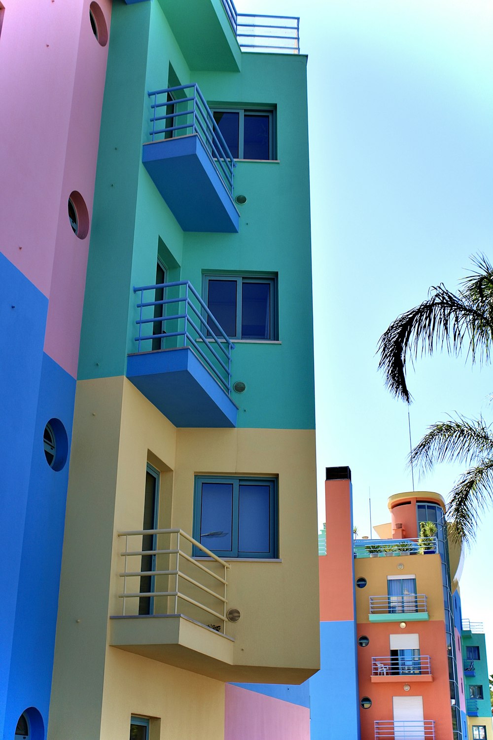 a building with balconies and a tree in the front