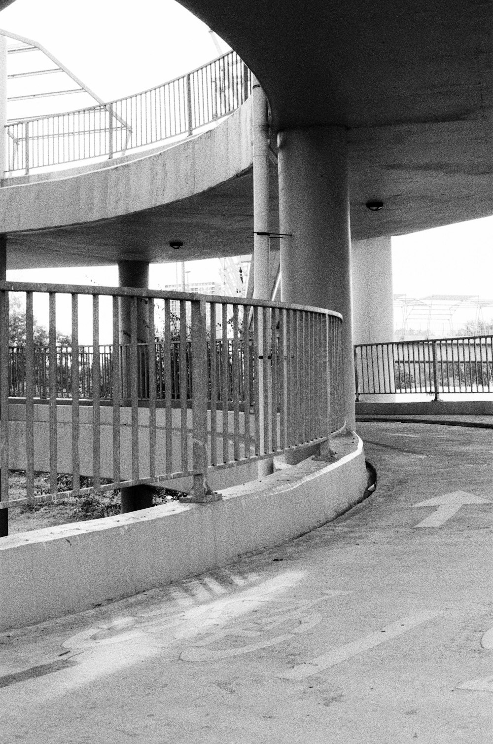 a black and white photo of a bridge with a railing