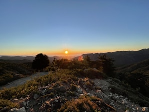 A breathtaking sunset over the rolling hills of Zacatlán, casting warm golden hues.