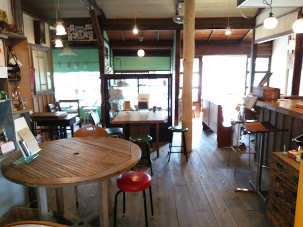 Cozy interior of Brisacafé with warm lighting and wooden tables.