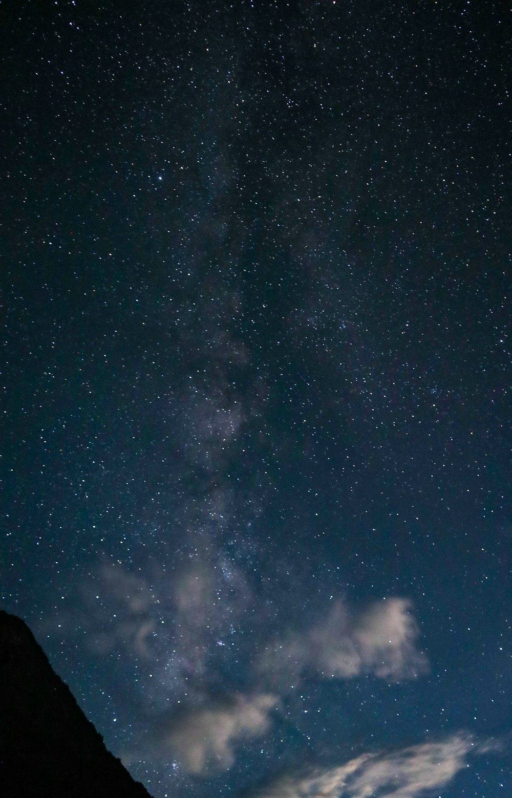 a starry night sky with a mountain and stars