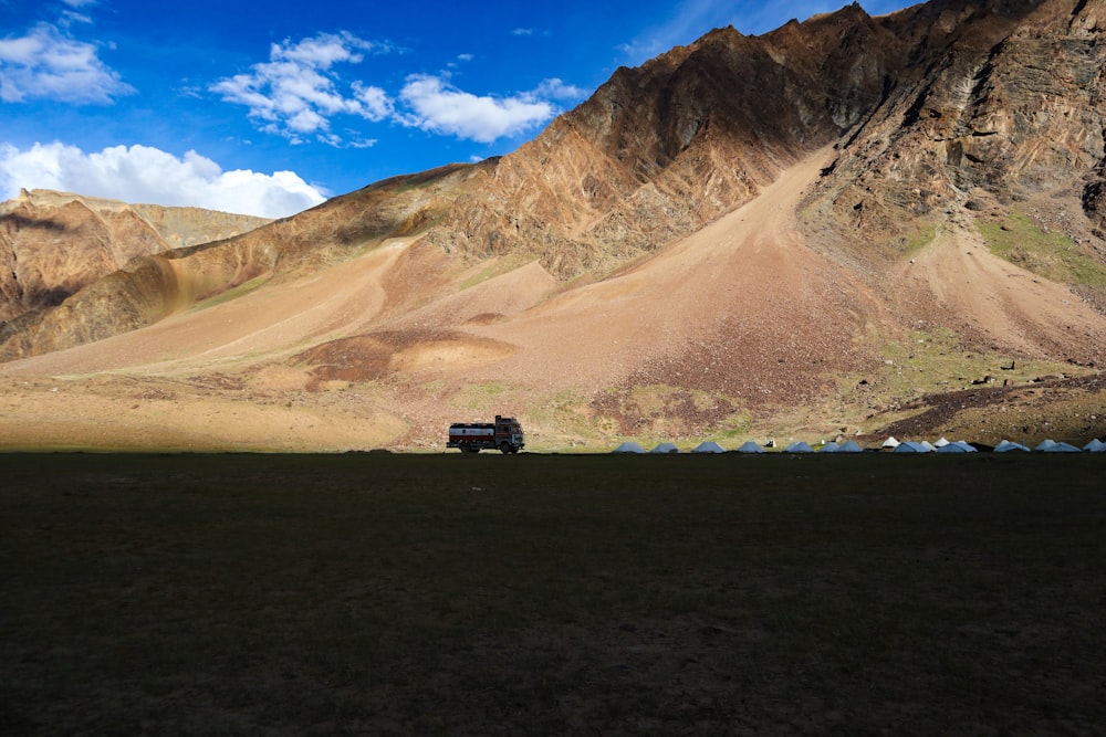 a truck driving on a road in a valley between mountains