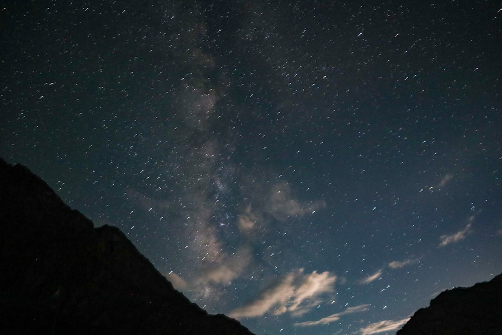 a starry night sky over a mountain range