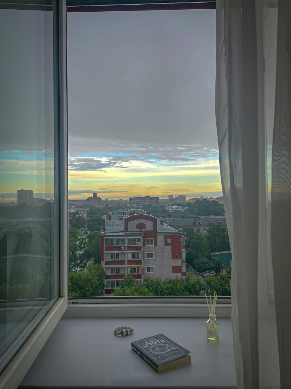 a window with a view of a city and a body of water