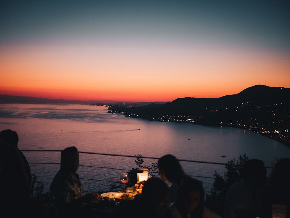 a group of people standing in front of a sunset