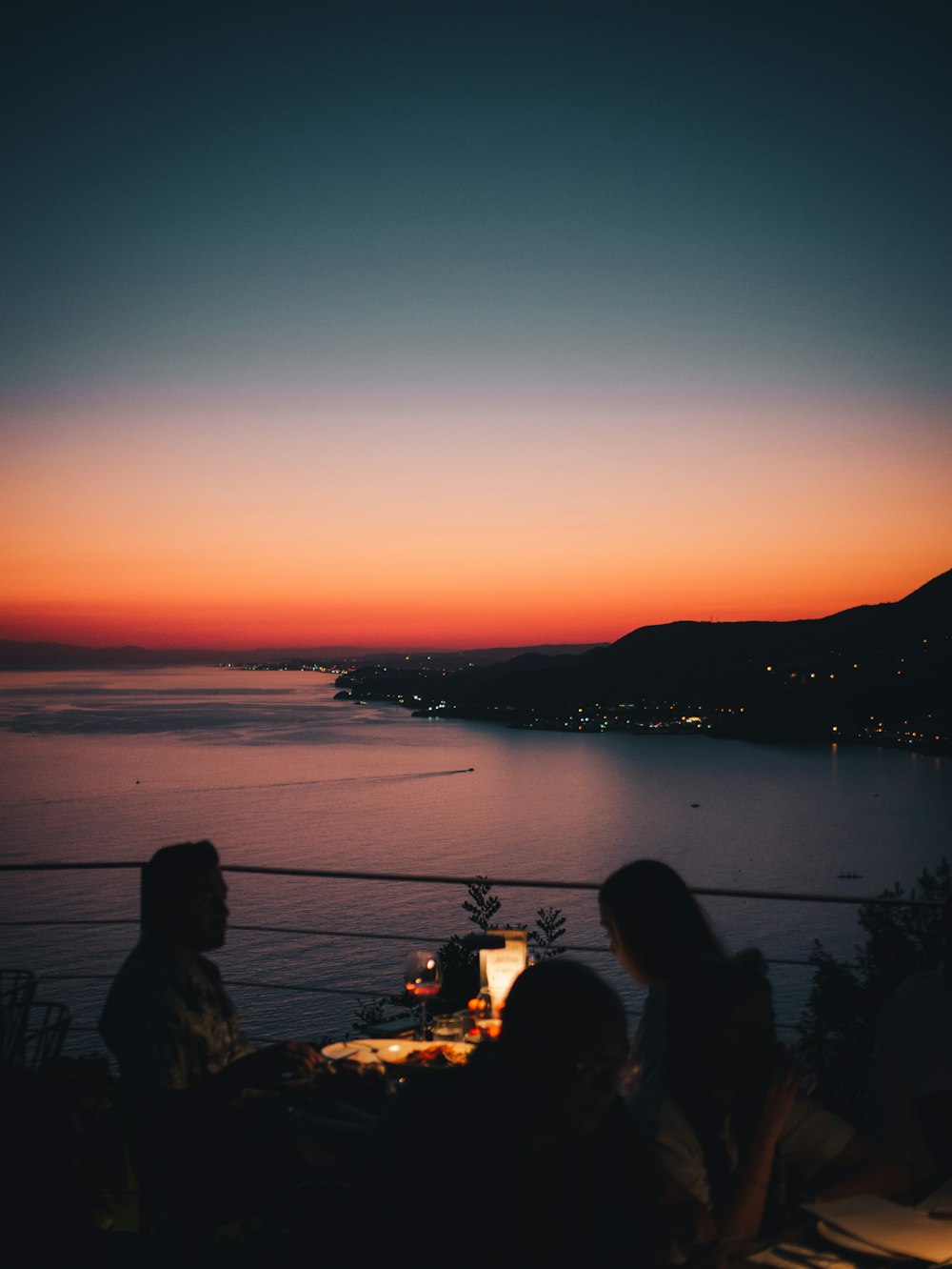 a group of people sitting at sunset