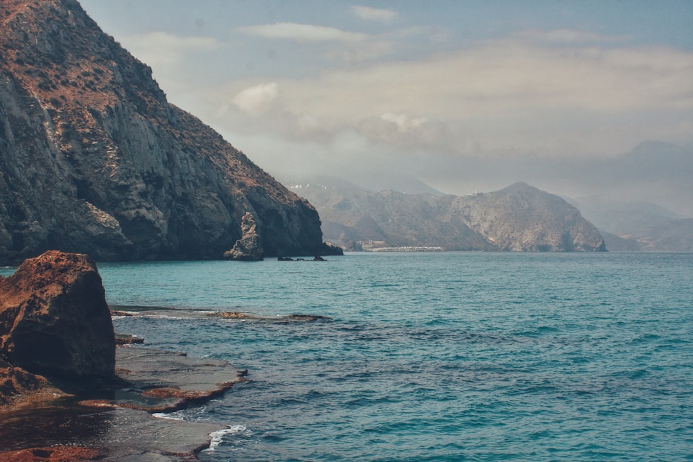 a body of water with mountains in the background