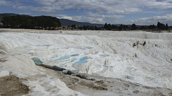 Pale blue pools held in white travertine basins — Pamukkale, Turkey