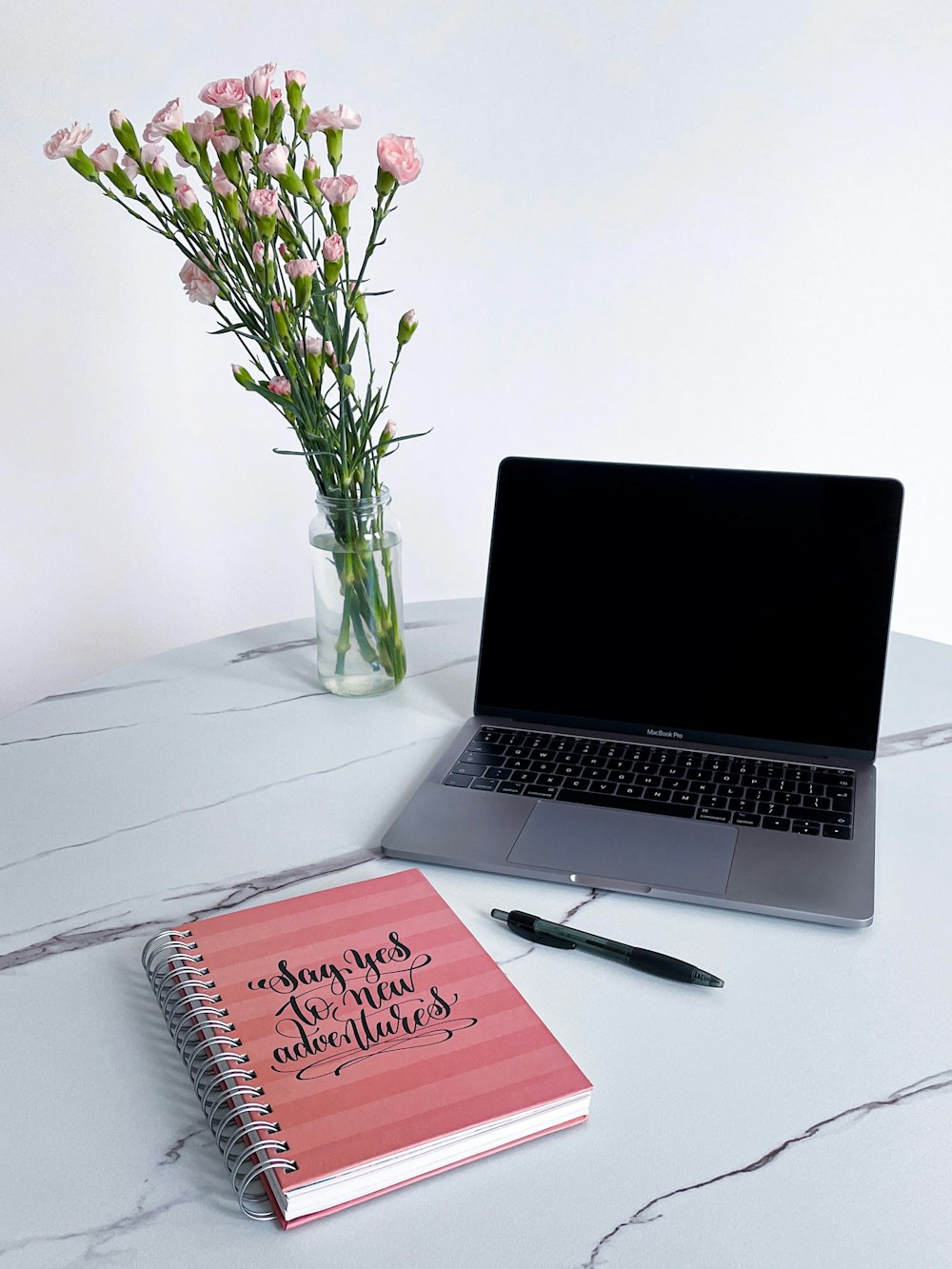 a laptop and a notebook on a table