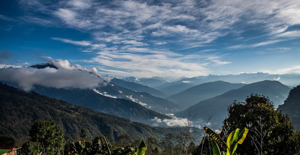 a view of a mountain range with clouds and blue sky