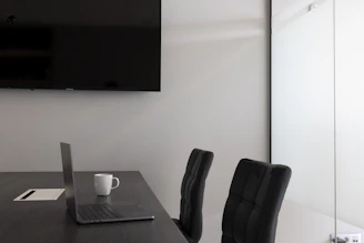 a desk with a laptop and a chair