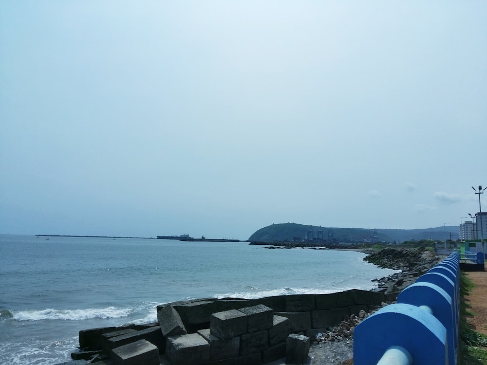 a rocky beach with a body of water in the background