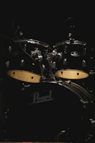 A sleek black drum set shining under soft studio lights.