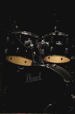 Minimalist black and blue drum kit setup with subtle lighting highlighting the cymbals.