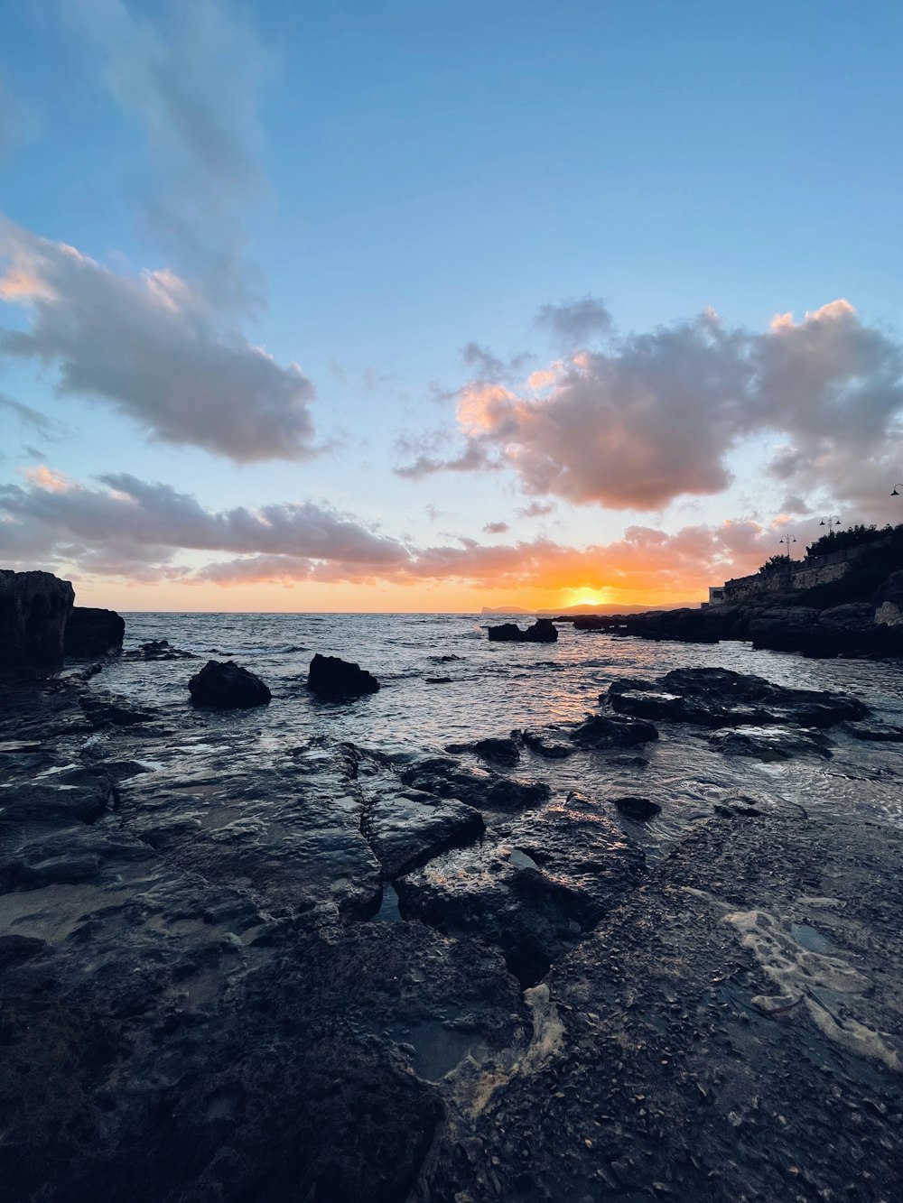 a rocky beach with a sunset