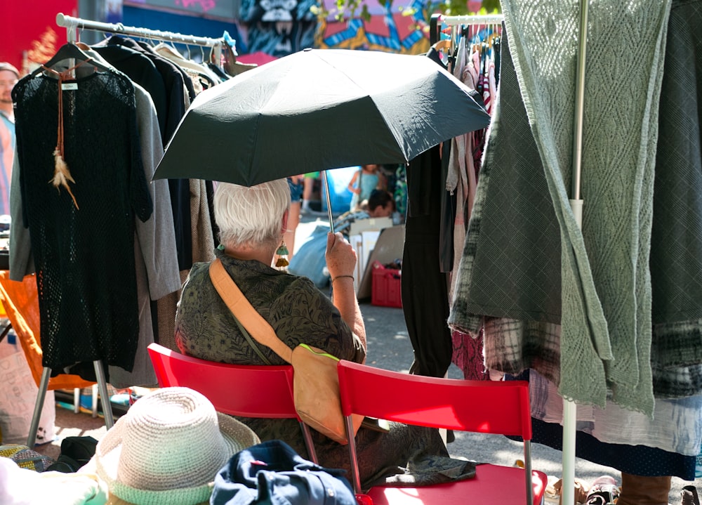 uma pessoa sentada sob um guarda-chuva