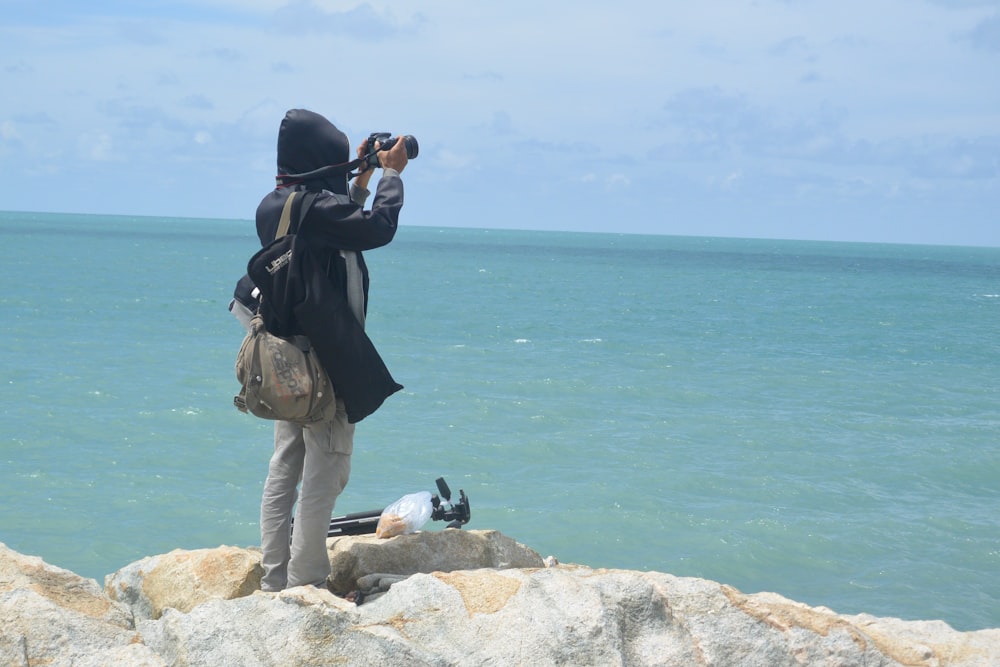 a person taking a picture of the ocean