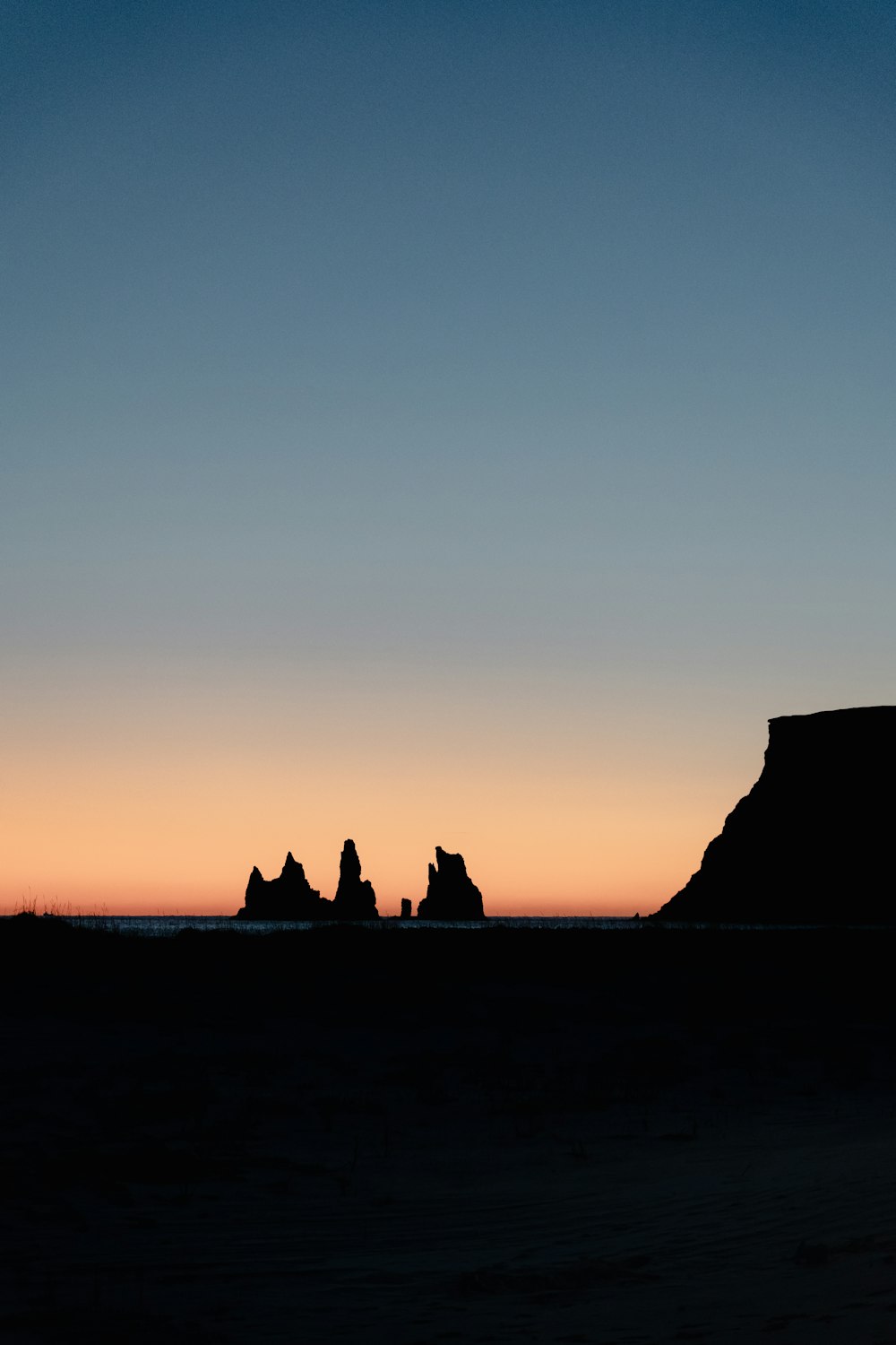 silhouette of people sitting on a rock