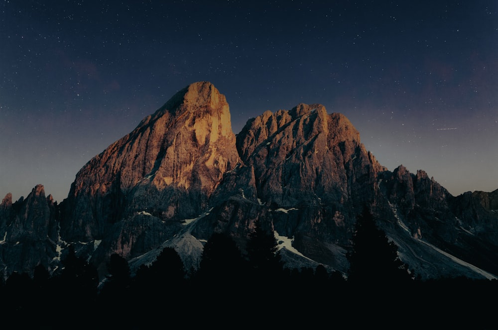 a snowy mountain with a starry sky above