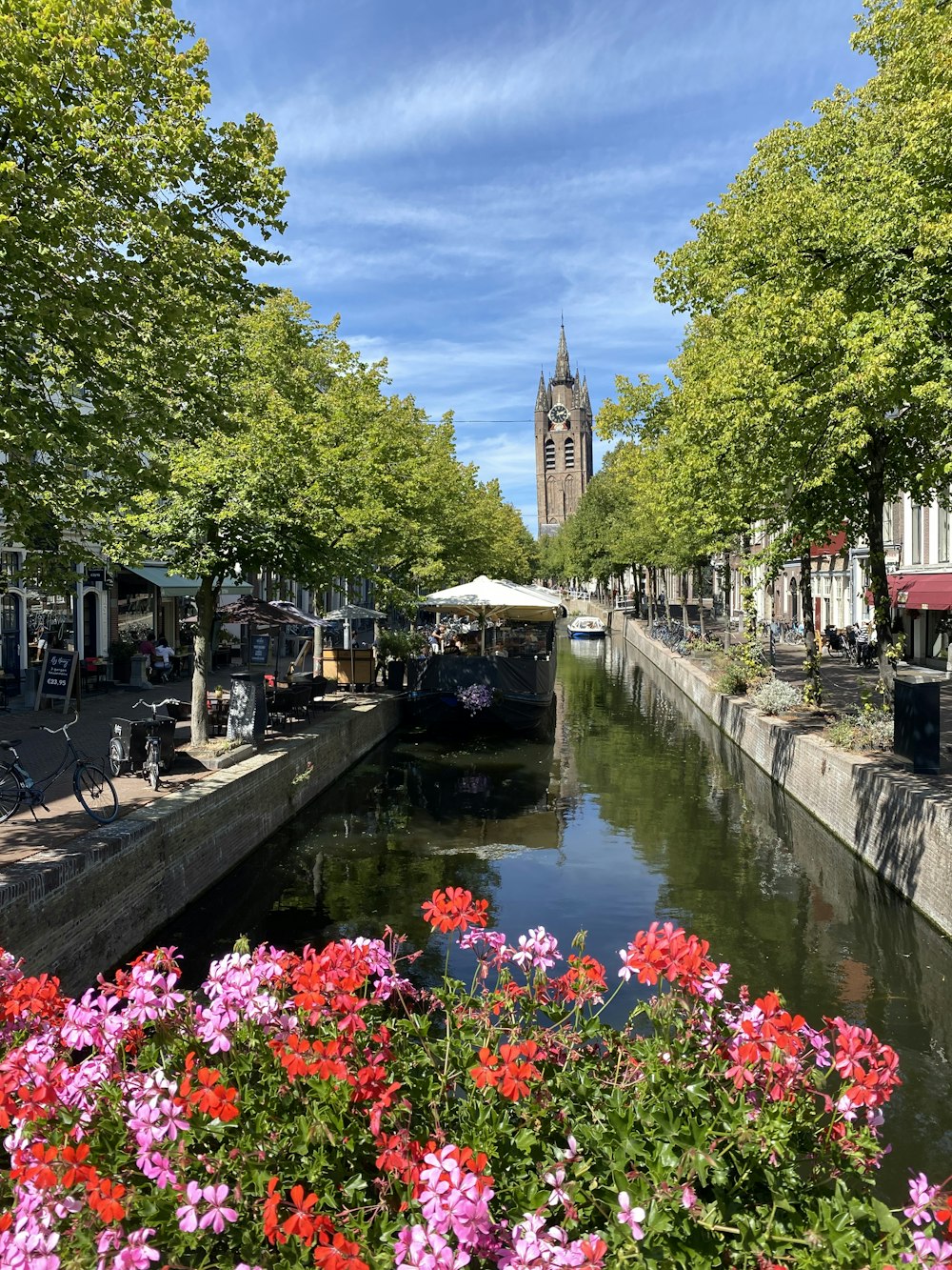 a river with a boat and flowers by it