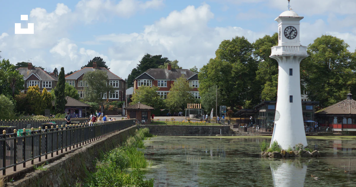 A clock tower next to a river photo – Free Roath park Image on Unsplash