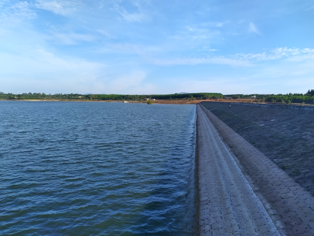 a body of water with a dock and trees in the background