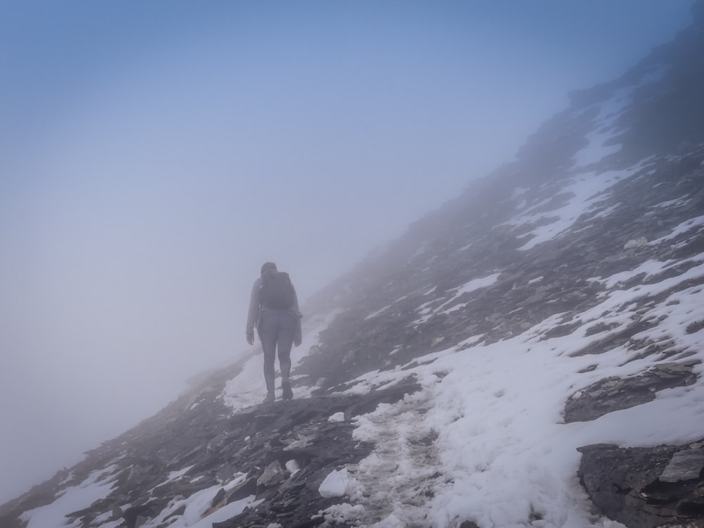 a man and woman walking on a snowy mountain