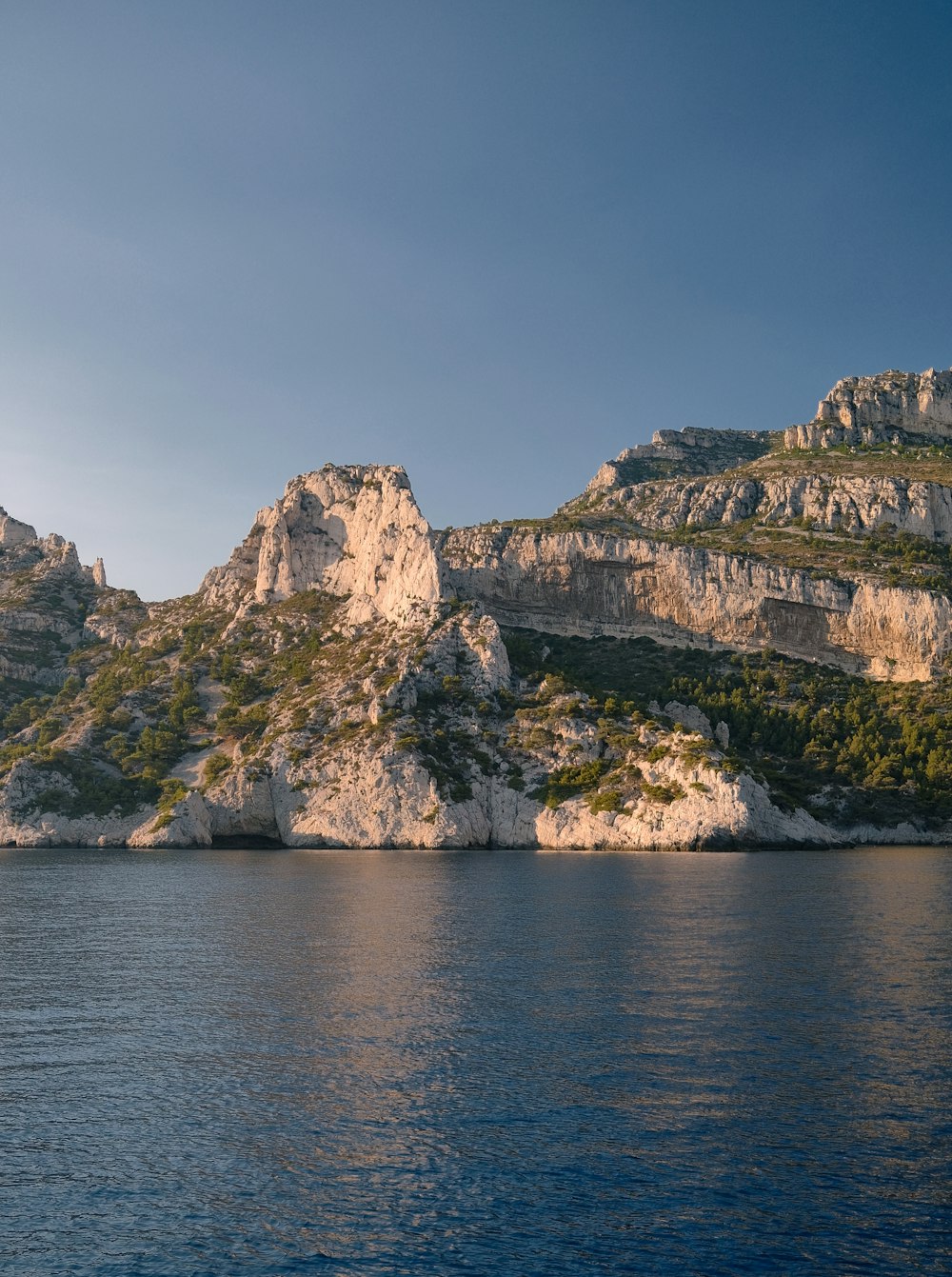 a rocky cliff next to a body of water