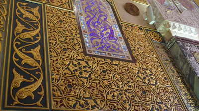 Close-up of intricate arabesque patterns layered with subtle gold gradients and soft glowing effects.