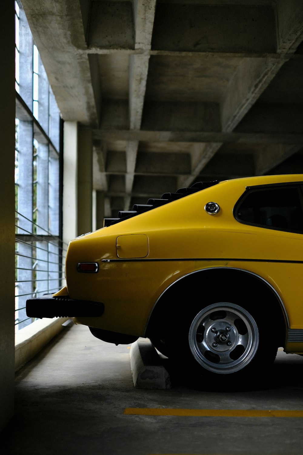 a yellow car parked in a parking garage