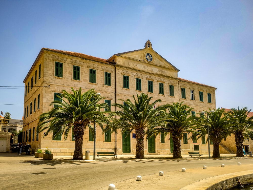 a large building with palm trees in front of it