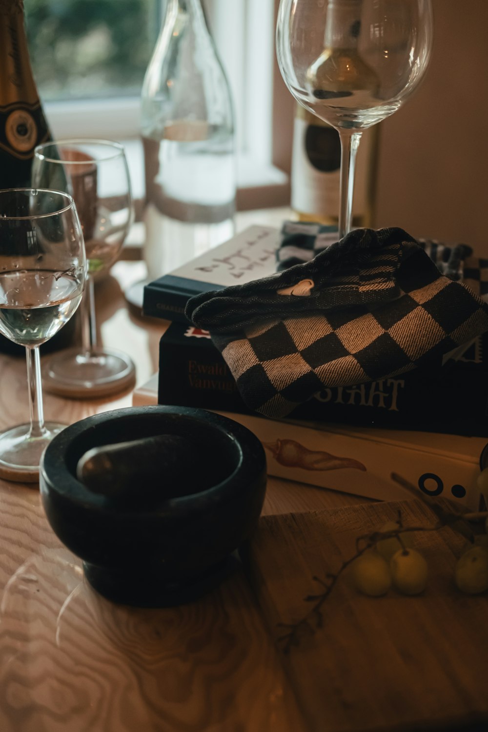 a black and white object on a wooden surface next to glasses