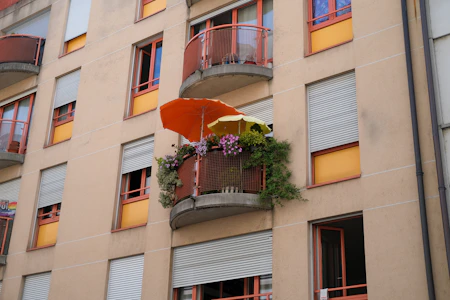 a building with a balcony and a potted plant on the balcony