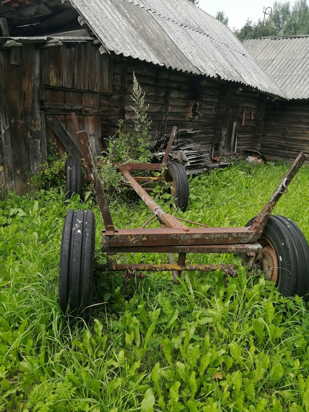 a wooden cart in front of a barn