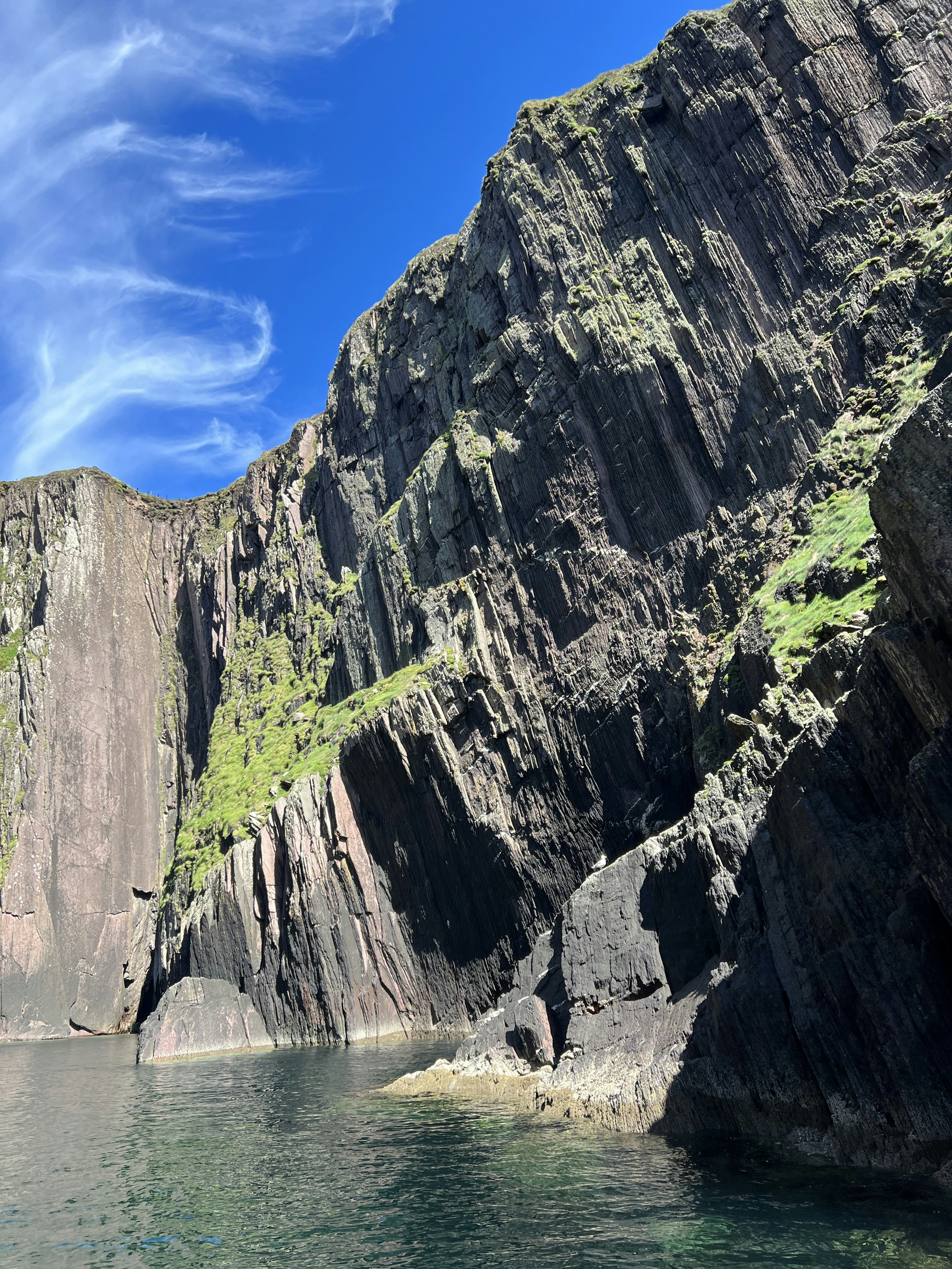 a cliff side with a body of water below