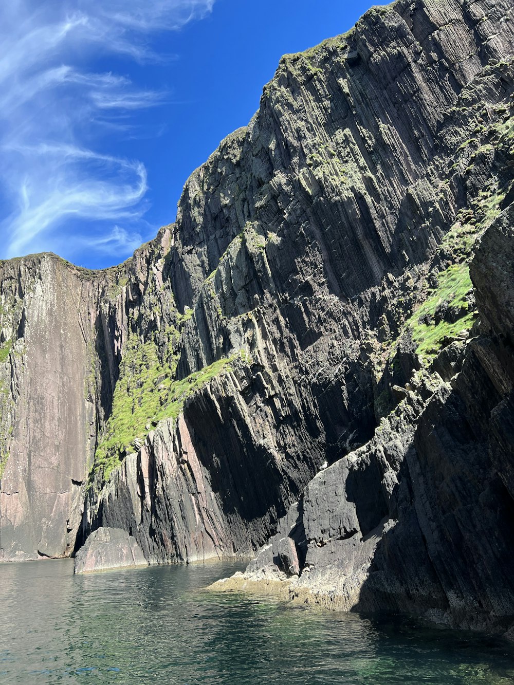 a cliff side with a body of water below